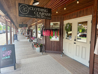 The JQ Clothing Co. + Hat Bar sign over the boardwalk in Medora, North Dakota in the fall.