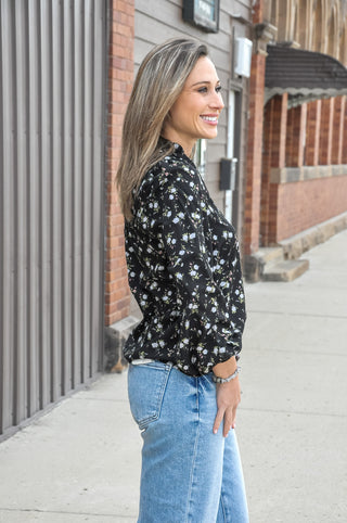 A delicate all-over print of cream and white roses on a rich black ground is framed by a frilled split V-neckline for a feminine, editorial touch that instantly elevates the look.