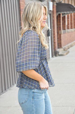 Effortlessly feminine and easy to style, this plaid peplum blouse is crafted from lightweight woven polyester in a soft blue grey palette. 