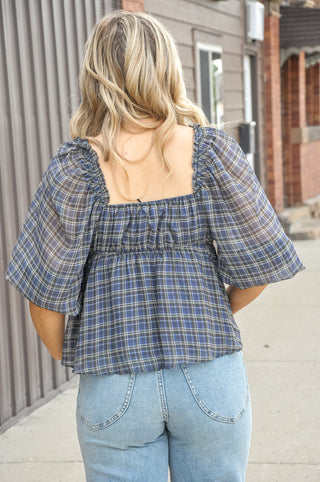 Effortlessly feminine and easy to style, this plaid peplum blouse is crafted from lightweight woven polyester in a soft blue grey palette. 
