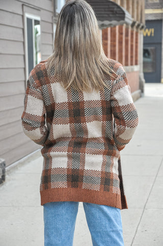  This copper checkered jacquard sweater coat features a tailored collar, open front silhouette, button detail, and pockets.
