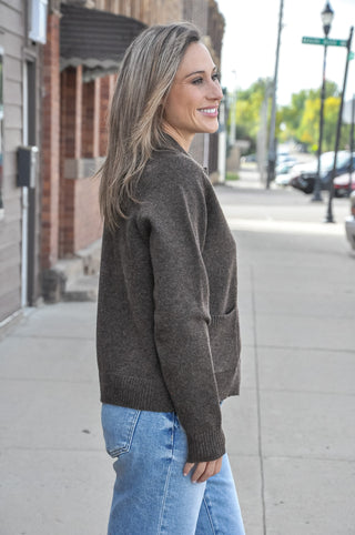 This collared button-down cardigan features a polished spread collar, side pockets, and a clean button-front closure that gives it a refined, put-together look — all while staying cozy and comfortable in a soft poly-wool blend.