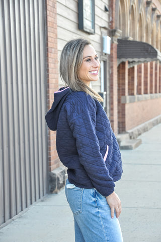 This quilted hoodie combines a half zip neckline with color-trimmed detail and dual pockets — a patch pocket and kangaroo pocket.