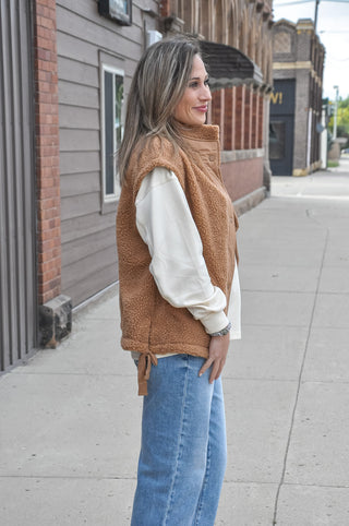 This cozy fleece vest features a soft, textured fabric with a clean minimal look that effortlessly elevates any outfit.