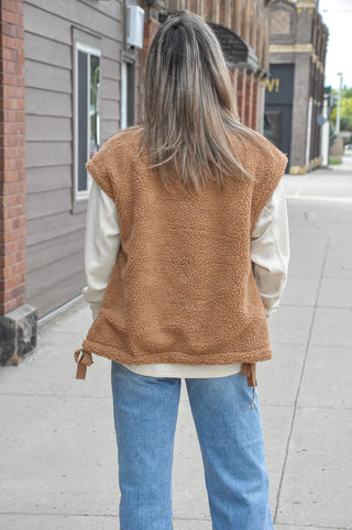 This cozy fleece vest features a soft, textured fabric with a clean minimal look that effortlessly elevates any outfit.