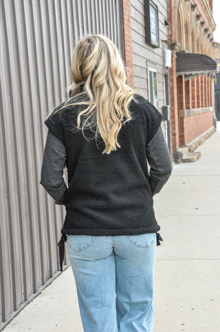 This cozy fleece vest features a soft, textured fabric with a clean minimal look that effortlessly elevates any outfit.