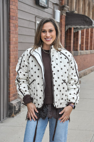  This cream quilted jacket puts a fun, fashion-forward spin on a classic silhouette with an allover polka dot print and contrast piping details that make it anything but ordinary. 