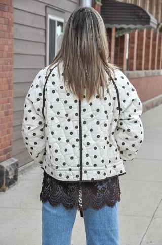  This cream quilted jacket puts a fun, fashion-forward spin on a classic silhouette with an allover polka dot print and contrast piping details that make it anything but ordinary. 