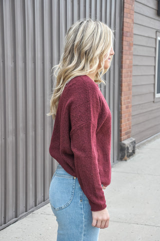 Designed in a beautiful Burgundy shade, this soft solid sweater features a classic crew neckline, long sleeves, and button-front detailing for a timeless, polished look.