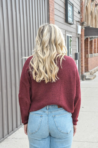 Designed in a beautiful Burgundy shade, this soft solid sweater features a classic crew neckline, long sleeves, and button-front detailing for a timeless, polished look.