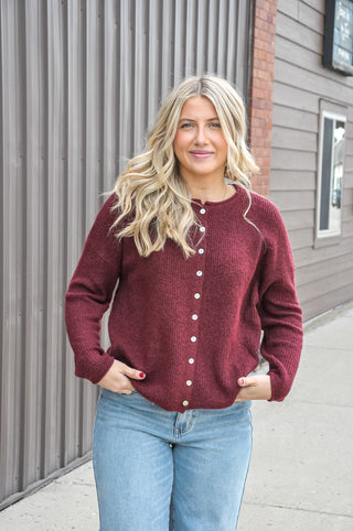 Designed in a beautiful Burgundy shade, this soft solid sweater features a classic crew neckline, long sleeves, and button-front detailing for a timeless, polished look.