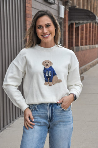 An adorable dog in a sporty sweater adds spirited charm, while the relaxed oversized fit keeps it easy to throw on and go.