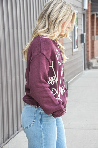 This crewneck cardigan is dressed up with delicate floral vine embroidery and charming contrast blanket stitch detailing.