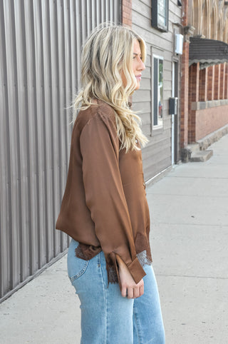 This satin loose fit shirt from Anniewear features a delicate lace hem detail that peeks out from under the silky fabric.