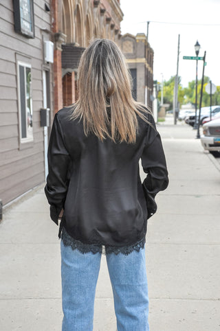 This satin loose fit shirt from Anniewear features a delicate lace hem detail that peeks out from under the silky fabric.