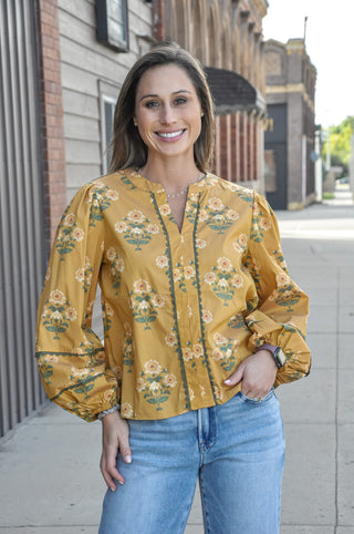 A split neckline with decorative contrast trim detail adds a thoughtful, feminine finish, while the long puff sleeves with elastic cuffs give it that effortlessly romantic, vintage-inspired feel.