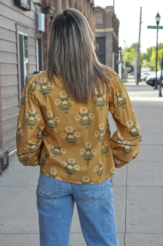 A split neckline with decorative contrast trim detail adds a thoughtful, feminine finish, while the long puff sleeves with elastic cuffs give it that effortlessly romantic, vintage-inspired feel.
