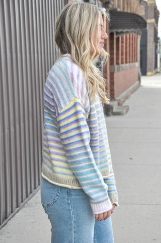  The fuzzy acrylic-poly knit has a plush, cozy feel that's as comfortable as it is eye-catching, while the horizontal multicolor stripes and full button-down front give it a playful, vintage-inspired charm. 