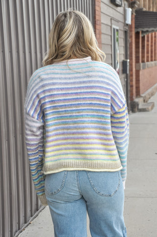  The fuzzy acrylic-poly knit has a plush, cozy feel that's as comfortable as it is eye-catching, while the horizontal multicolor stripes and full button-down front give it a playful, vintage-inspired charm. 