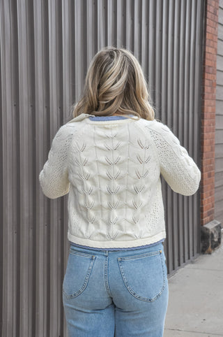 Contrast trim sharpens the soft open-knit pattern, while the polished button front, crew neckline, and slim long sleeves make it an easy match for high-waisted skirts, denim, and dresses.