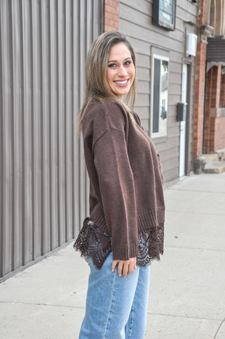 Soft-touch knit pairs with a scalloped hem and contrast floral lace trim for a feminine finish, while the loose fit keeps every layer easy and comfortable.