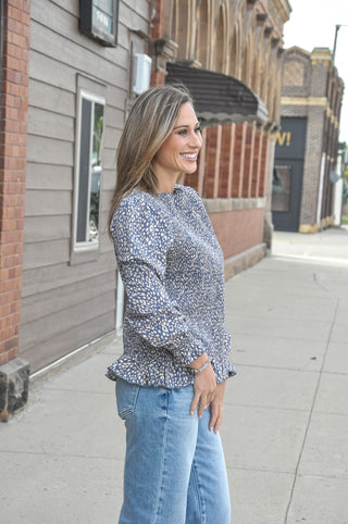 This long sleeve peplum top features a fully smocked bodice that hugs your curves in all the right places, a chic mock neck with delicate lettuce edging, and a flirty peplum hem that adds just the right amount of flair.