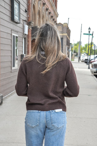 The wool-blend sweater knit is finished with gingham ruffle trim and coordinating button accents for a polished look that still feels easy.
